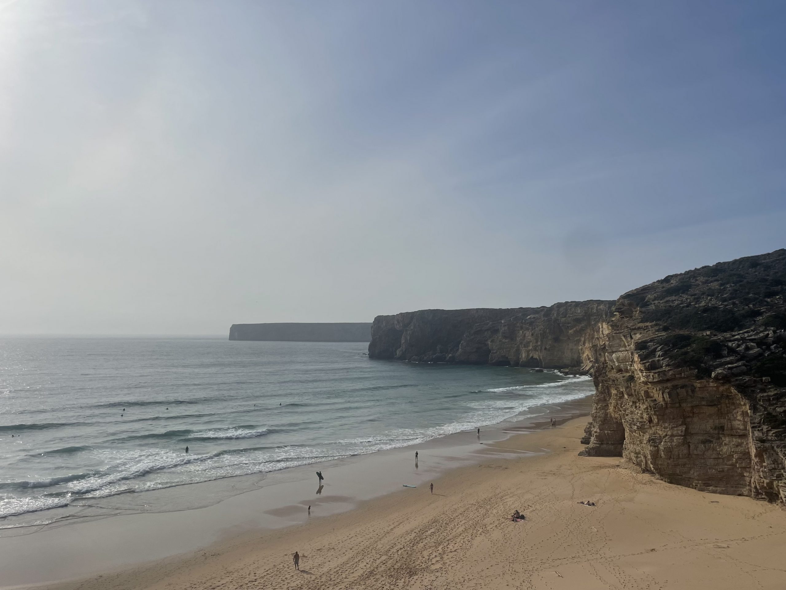Vista de un campo amplio y montañas al fondo y una preciosa playa